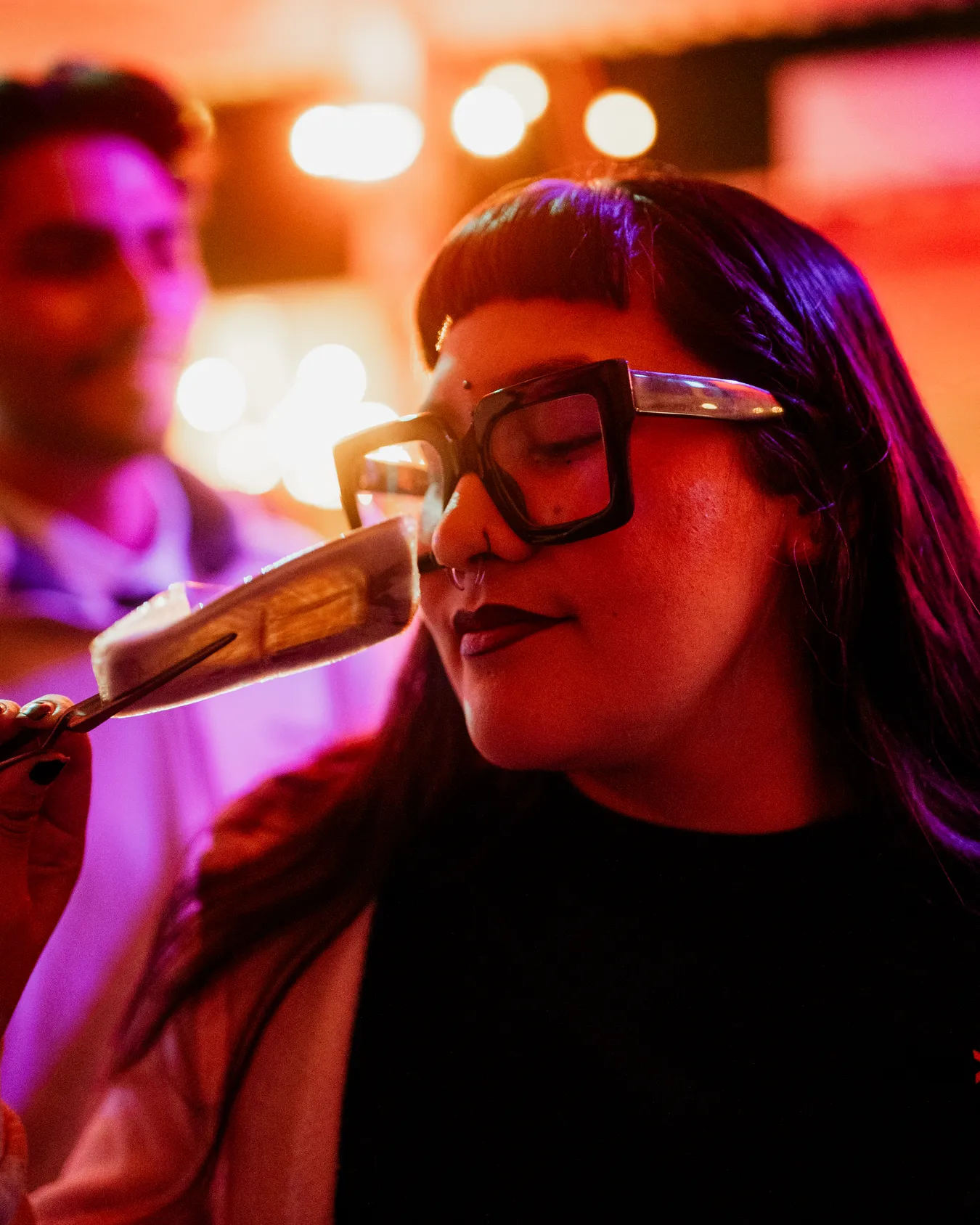 A guest taking in the aroma of cannabis at a Flower Hour, eyes closed.